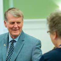 President T-Haas shakes the hand of an alumna at the Reunion Dinner.